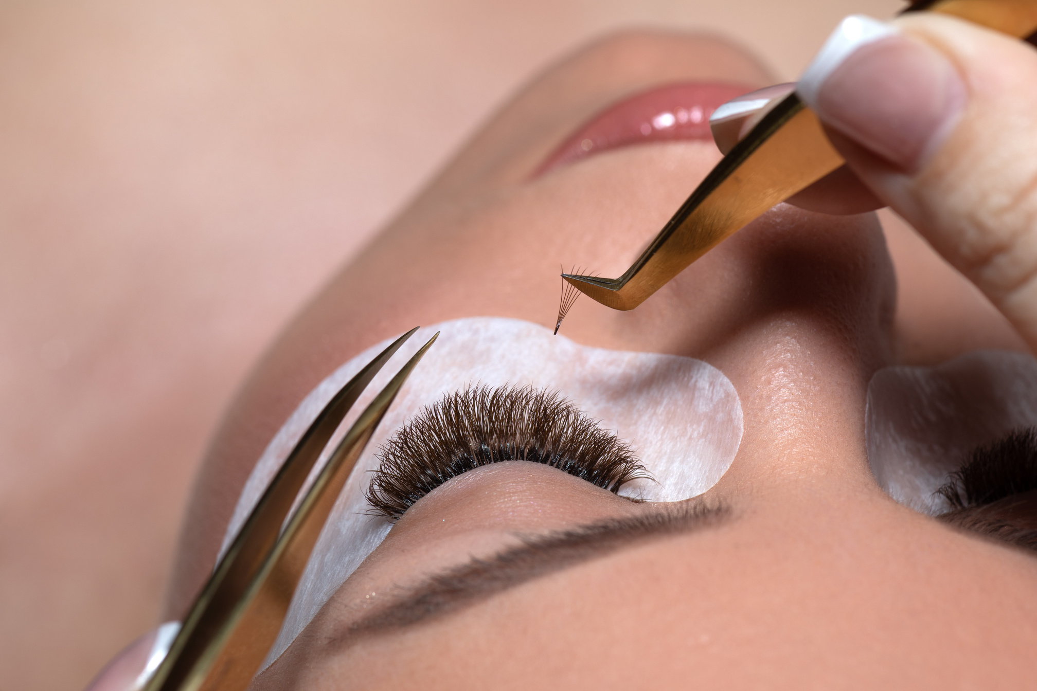 Eyelash Extension Procedure. Woman Eye with Long Eyelashes